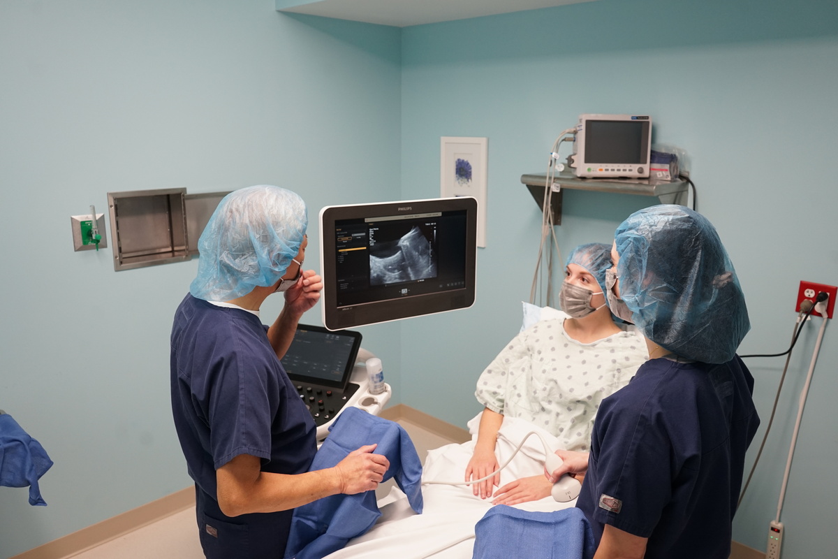 Two nurses with patient looking at ultrasound