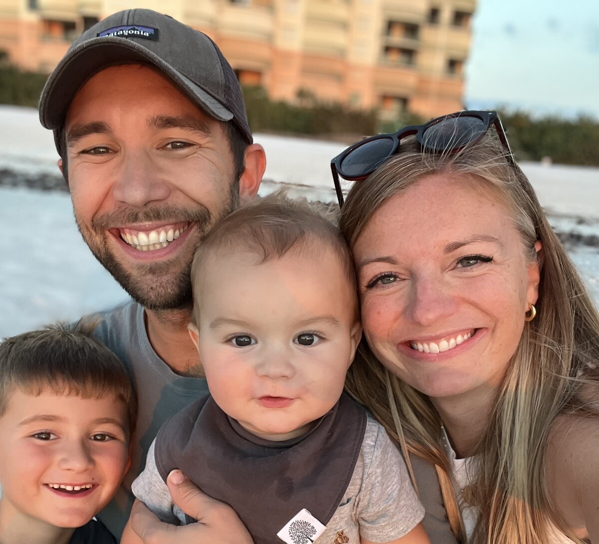 a man and a woman smiling with a toddler and a baby